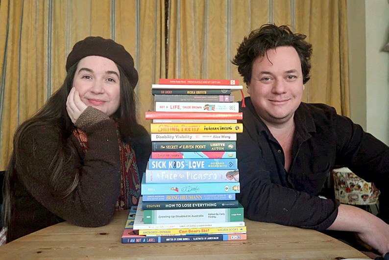 photo of Lucy and James Catchpole at a table with a stack of books